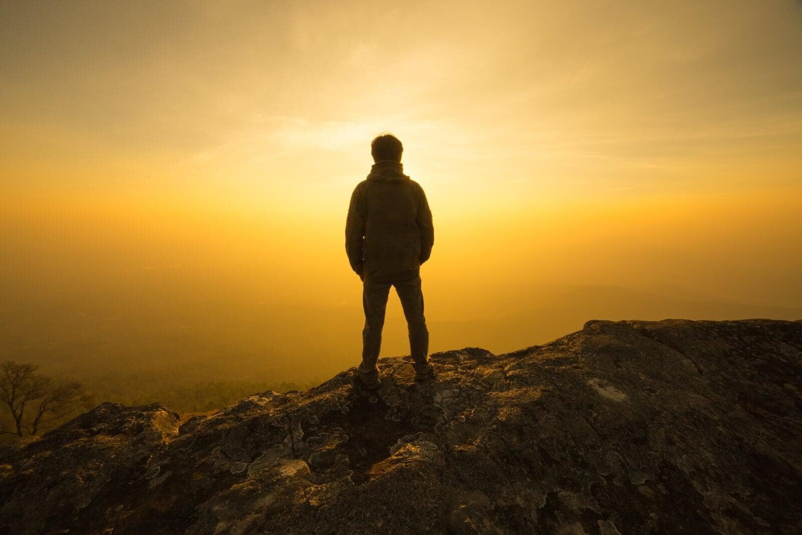 Hiker at very top of mountain peek overlooking the valley